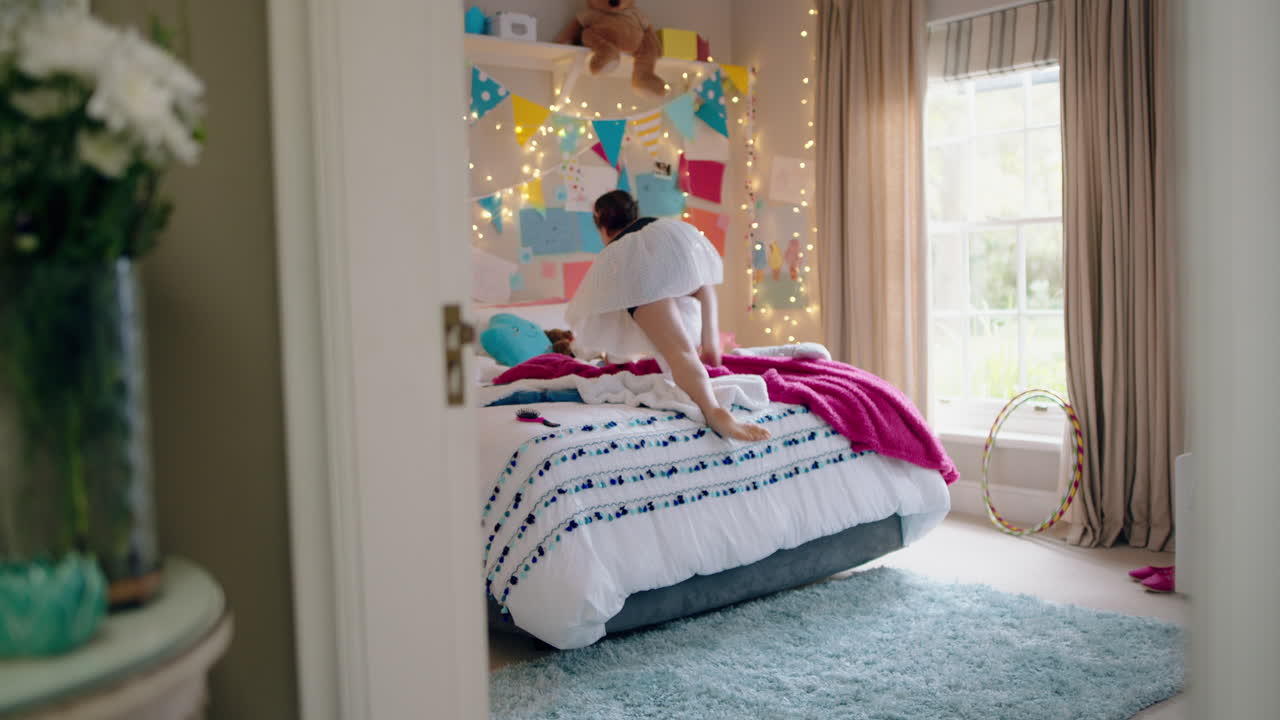 glückliches teenager-mädchen tanzt auf dem bett, trägt eine ballett-tutu, hat spaß und tanzt mit einem teddybären im schlafzimmer
