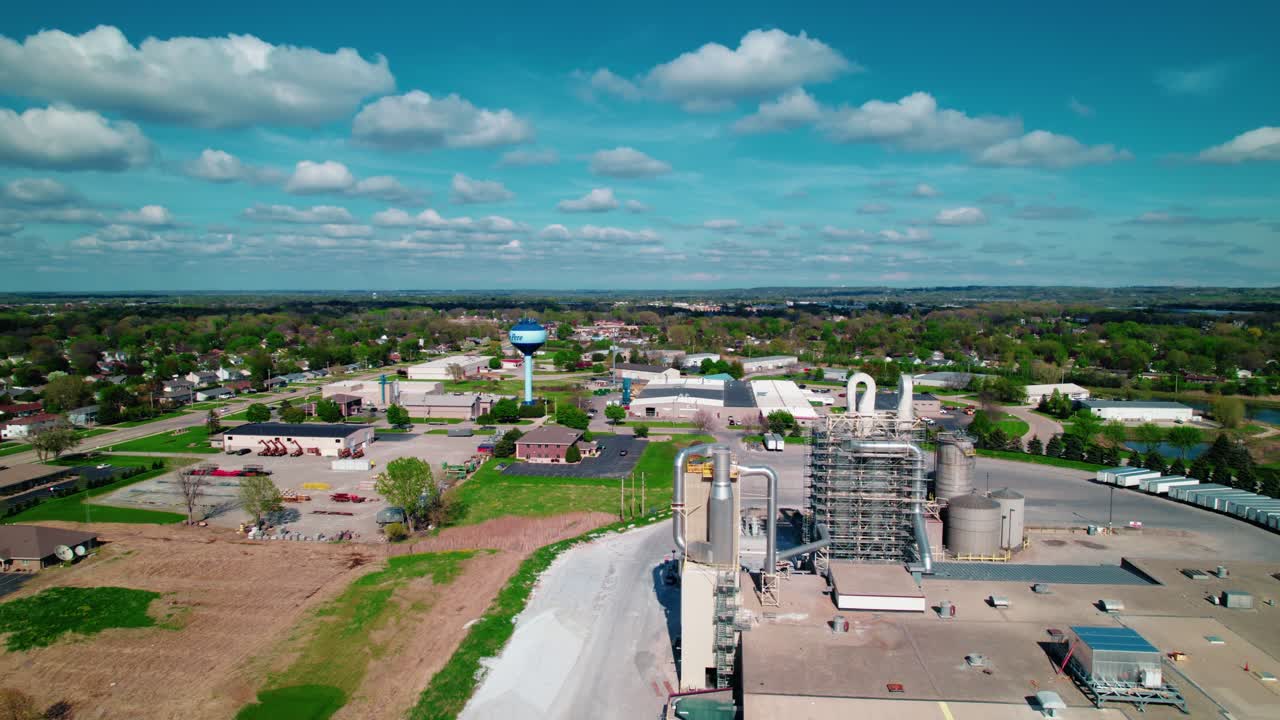 Wisconsin industrial plant set in a small-town landscape, with residential neighborhoods and bright skies