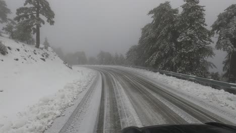 view out the front of a car driving down a snowy mountain road