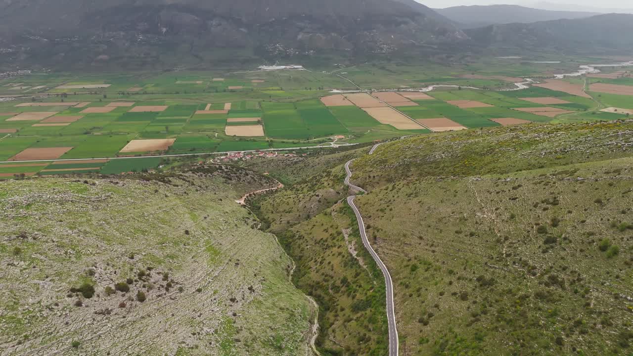 Tranquil Albania valley view with winding road amid lush green hills