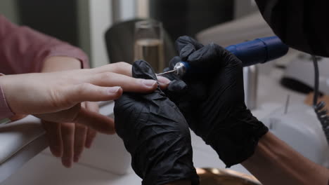 woman getting a manicure with a nail drill