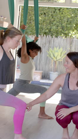 vertical video of diverse women exercising with gymnastic sashes and female coach, slow motion