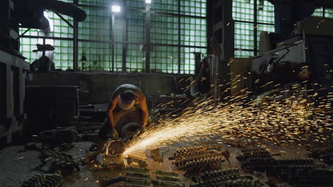 industrial worker grinding metal with sparks flying at a workshop