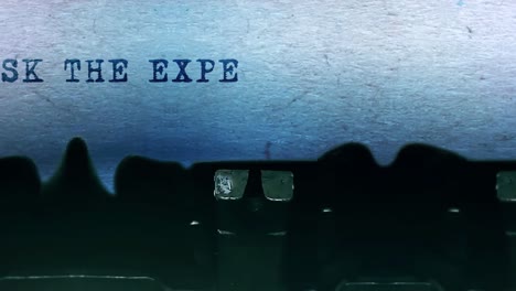 ask the expert word closeup being typing and centered on a sheet of paper on old vintage typewriter