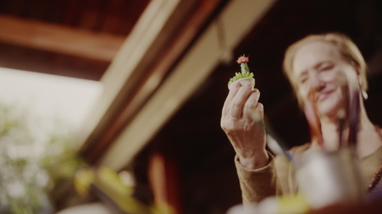 A woman holding a small succulent plant indoors