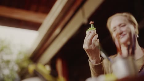 a woman holding a small succulent plant indoors
