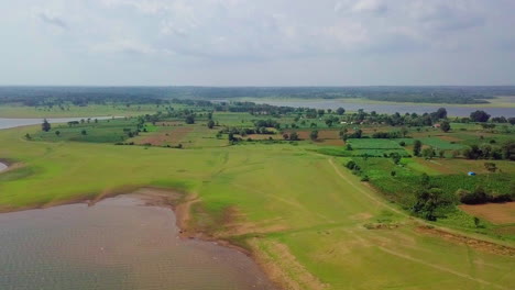 lush green fields stretch beside the scenic kabini river under a cloudy sky in nagarahole