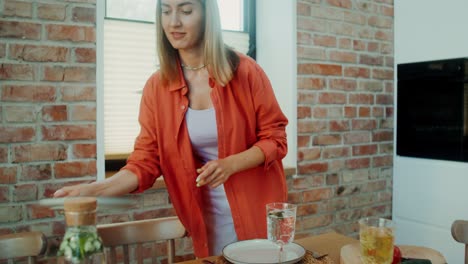 mujer colocando una mesa en una cocina moderna