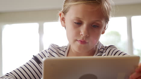 niña en la mesa con tableta digital en el hogar durante la pandemia de salud
