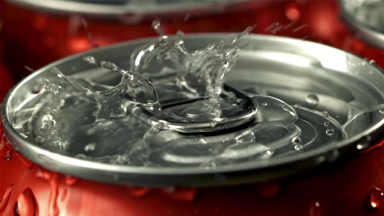 Água Refrescante Espirrando em uma Lata de Refrigerante Vermelha Gelada
