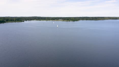 beautiful drone shot flying over lake at stony creek metropark in michigan