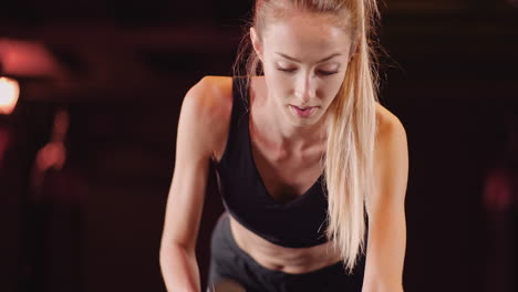 Confident-Young-Female-Athlete-Doing-Dumbbell-Row-Exercise-During-Fitness-Training