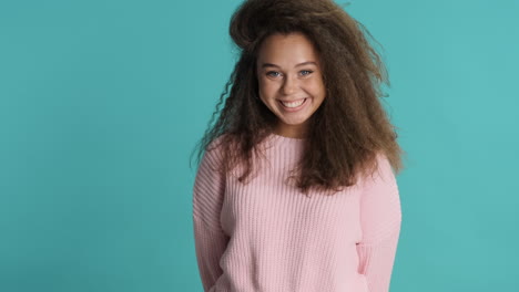 caucasian curly haired woman waving to the camera.