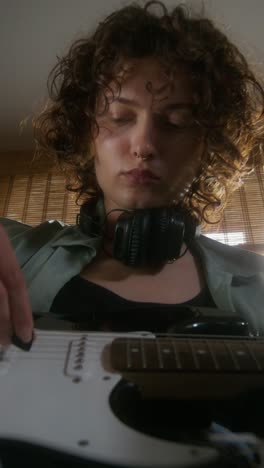 woman playing electric guitar at home