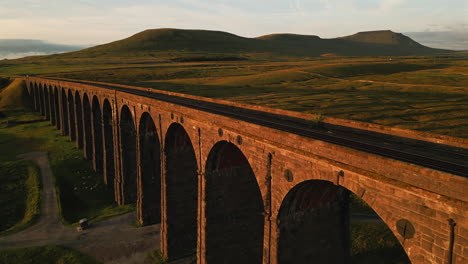 closeup drone shot of ribblehead viaduct with ingleborough in background at golden hour