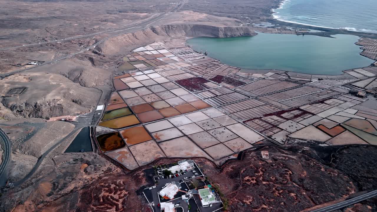 Beautiful aerial drone footage of the Salinas de Janubio salt flats at sunset in Lanzarote, Canary Islands, Spain.