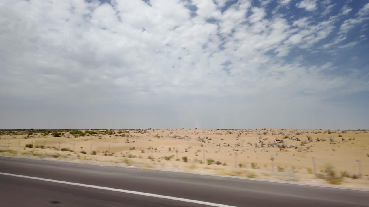 Driving on road through Karakum Desert landscape, Turkmenistan, Central Asia