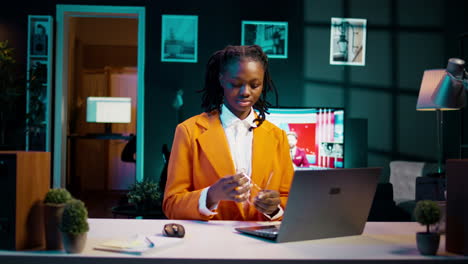 Portrait-of-african-american-student-putting-glasses-on-and-working