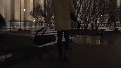 traveler with backpacks sitting down on the bench and using tablet pc