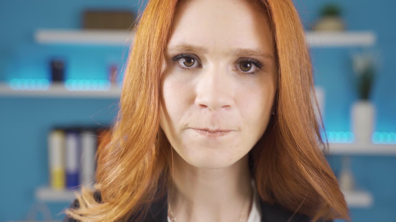Depressed woman getting angry looking at camera in office.