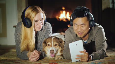 Joven-Pareja-Disfruta-Tableta-Mentira-Junto-A-La-Chimenea