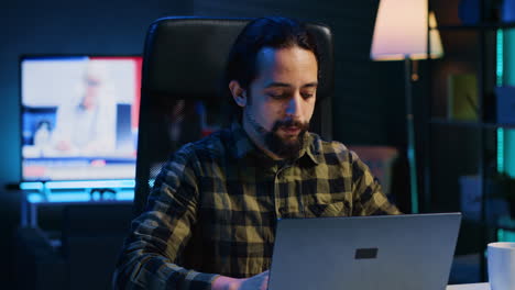 retrato de un trabajador independiente sonriente trabajando desde casa, escribiendo en una computadora portátil