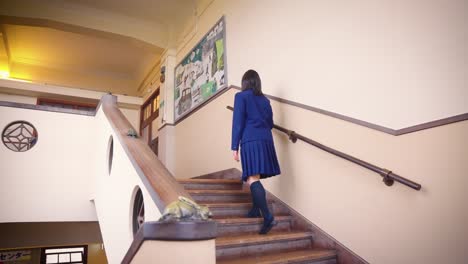 girl in school uniform slowly climbs staircase in between classes