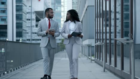 confident african american managers walking on street and talking