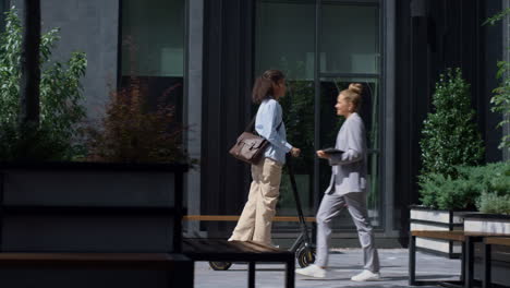 smiling businesswoman riding electric vehicle at downtown district. modern city