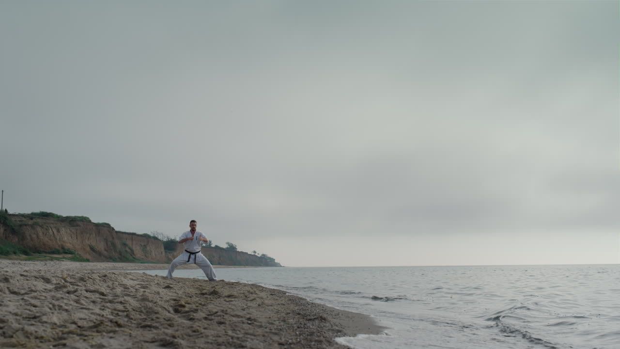 해변에서 무술 훈련을 하는 남자, 카라테를 연습하는 운동 선수