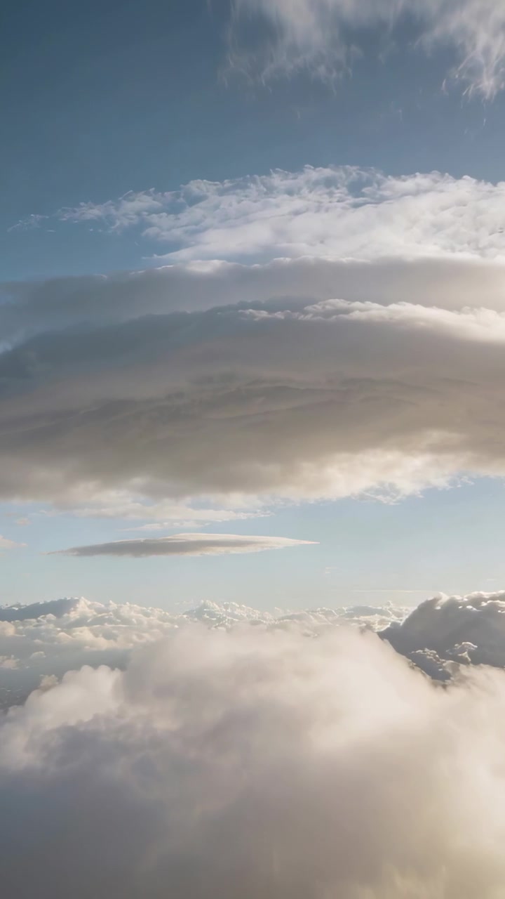 Video verticale: Drone che si inclina rivelando nuvole di media altezza su cielo blu che mostra un banco di cumuli alla deriva
