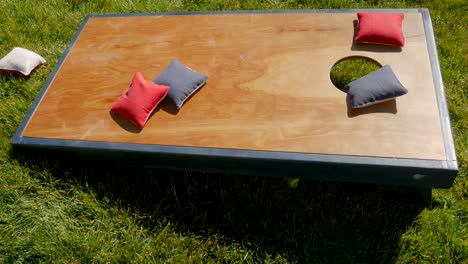 Isolated-shot-of-a-cornhole-board-as-the-corn-bags-land-on-it-during-a-game