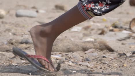 un niño recogiendo mármol en una playa contaminada cerca de carter road, mumbai, india.