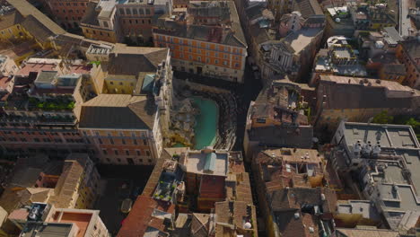 Aerial-footage-of-famous-tourist-attraction,-baroque-Trevi-Fountain.-Sightseeing-people-in-historic-city-centre.-Rome,-Italy