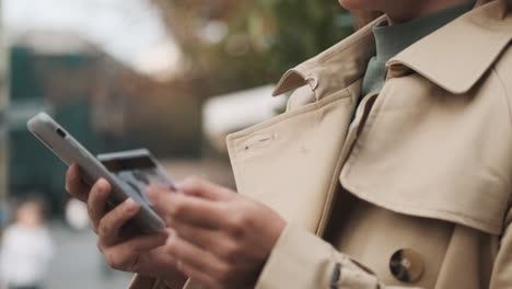 caucasian female student online shopping on smartphone outdoors.