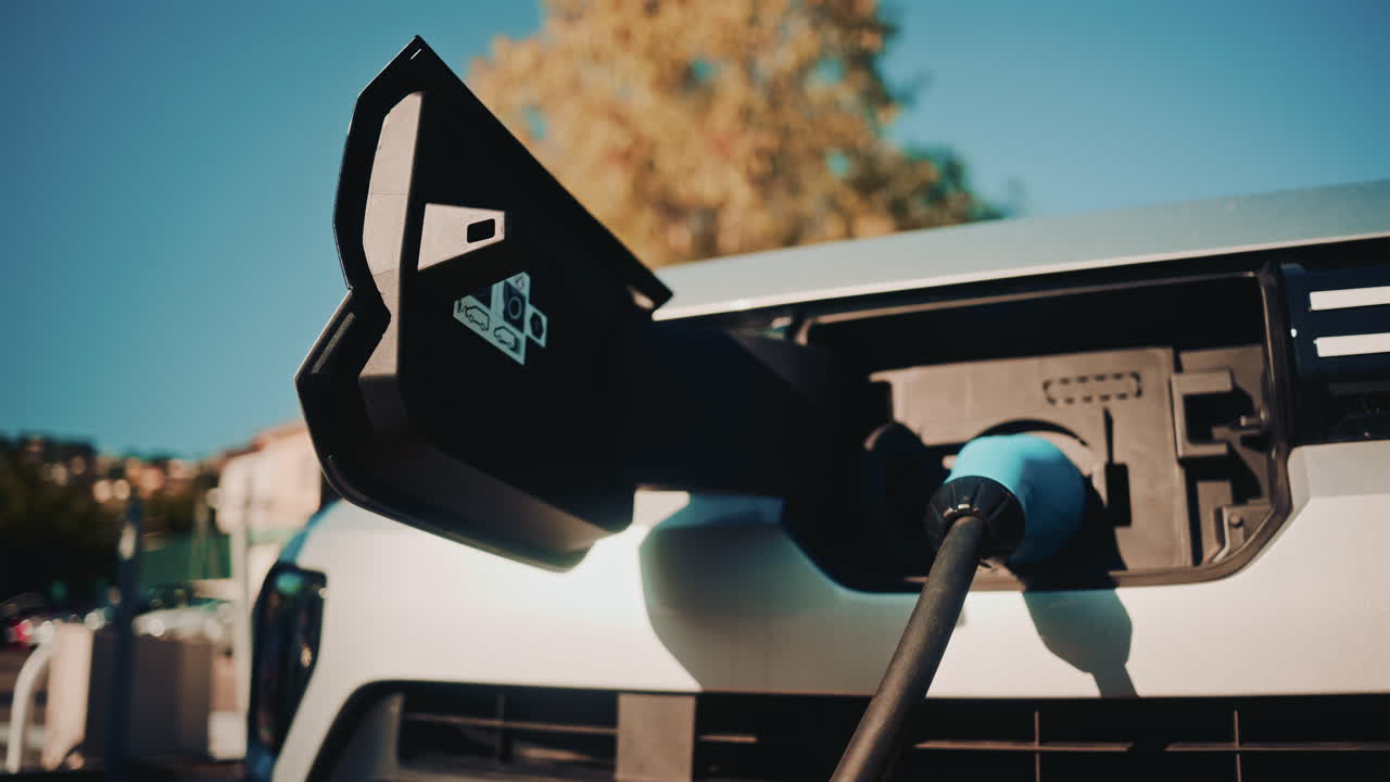 Close up shot of an electric vehicle charging port with cable connected