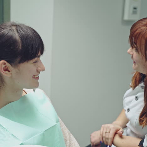 a young woman is sitting on a chair in the dental office on the consultation. dentist talks about teeth care. close-up.