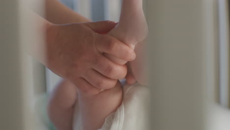 Adult hands gently holding a baby's feet