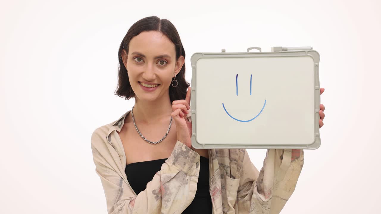 Woman with a smile drawing on whiteboard