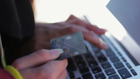 manos femeninas escribiendo el número de la tarjeta en la computadora portátil