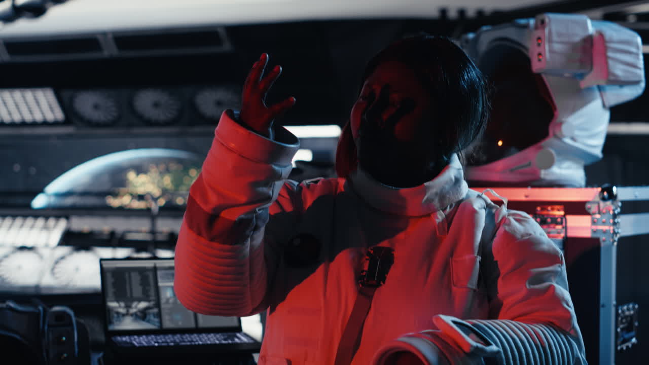 Astronaut shielding eyes from blinding alien vessel red light.