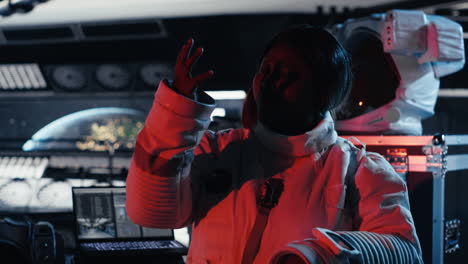 astronaut shielding eyes from blinding alien vessel red light.