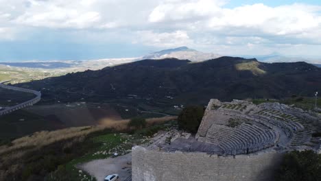 rotating aerial of an ancient greek theater on a hill in a lush green valley