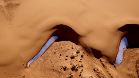 pink dunes and curious formations come alive in this vertical drone shot from above southern utah.