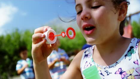 Nahaufnahme-Eines-Schulmädchens,-Das-Auf-Dem-Spielplatz-Mit-Einem-Seifenblasenstab-Spielt