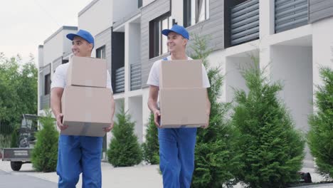 two young workers of removal company deliver boxes to a customer's home