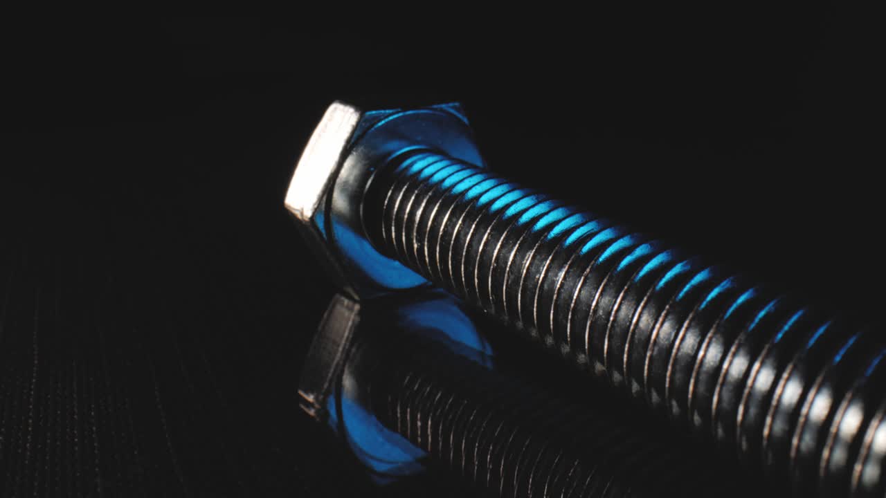 toma macro de un perno en una superficie negra reflectante usando una lente de sonda