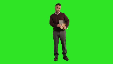 Full-Length-Studio-Portrait-Of-Mature-Male-Teacher-Or-Businessman-Standing-Against-Green-Screen-Carrying-Folder