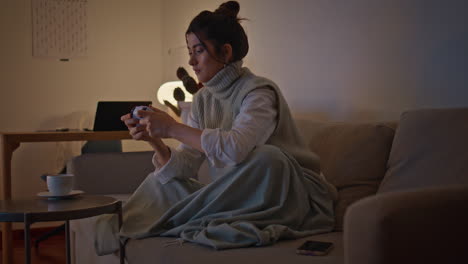 excited woman playing gamepad at late apartment. involved lady having playtime