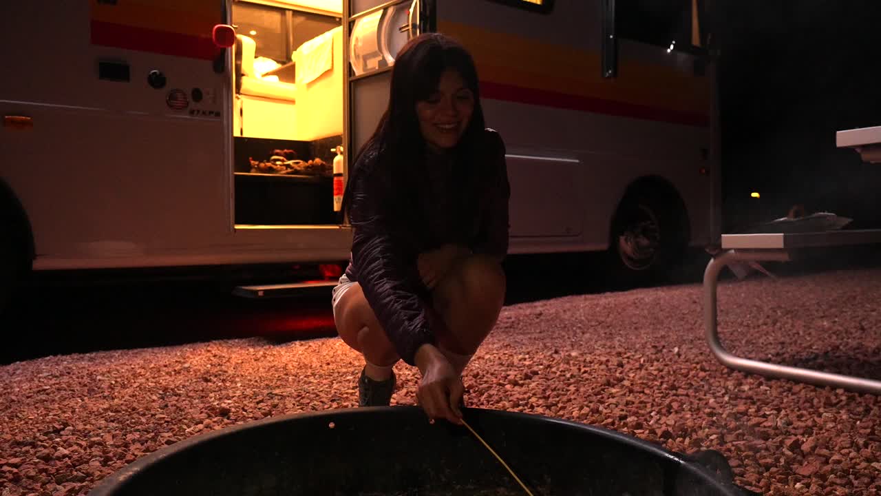 Happy Woman Roasting Marshmallow Over Campfire at Night